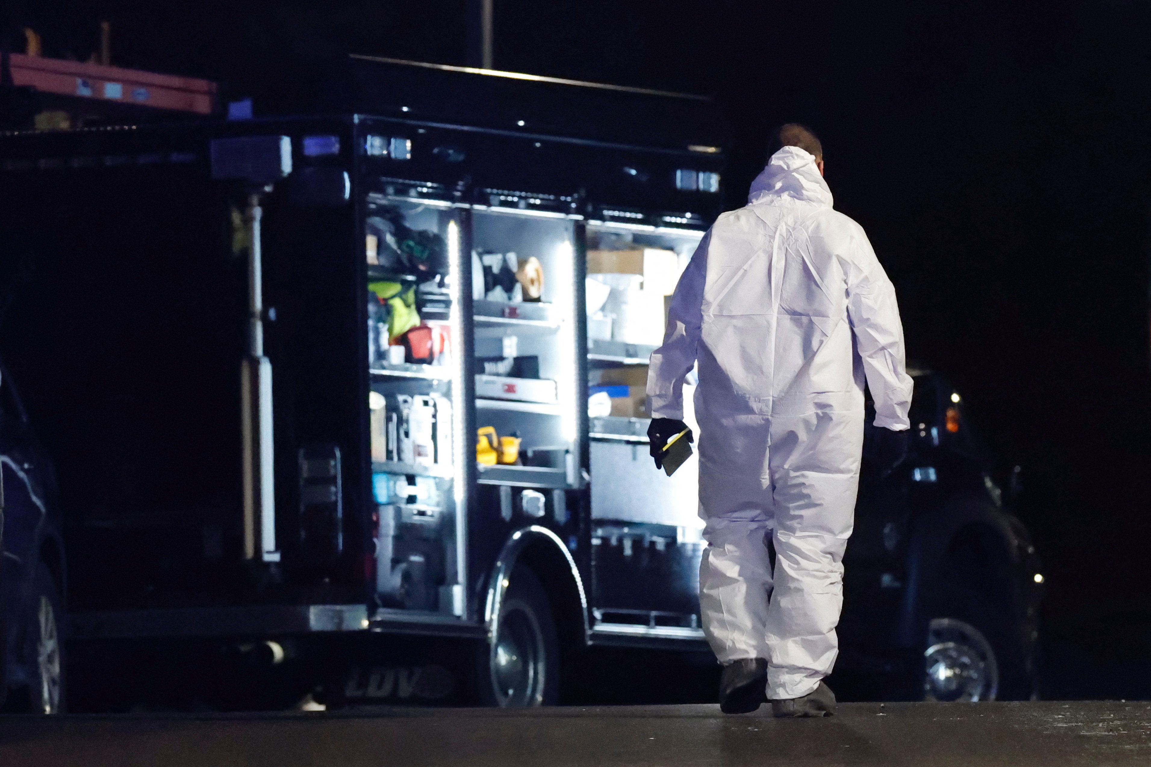 یک بازپرس در حال بررسی صحنه در انباری است که مظنون به تیراندازی دانشگاه براون در آن خودکشی کرد.