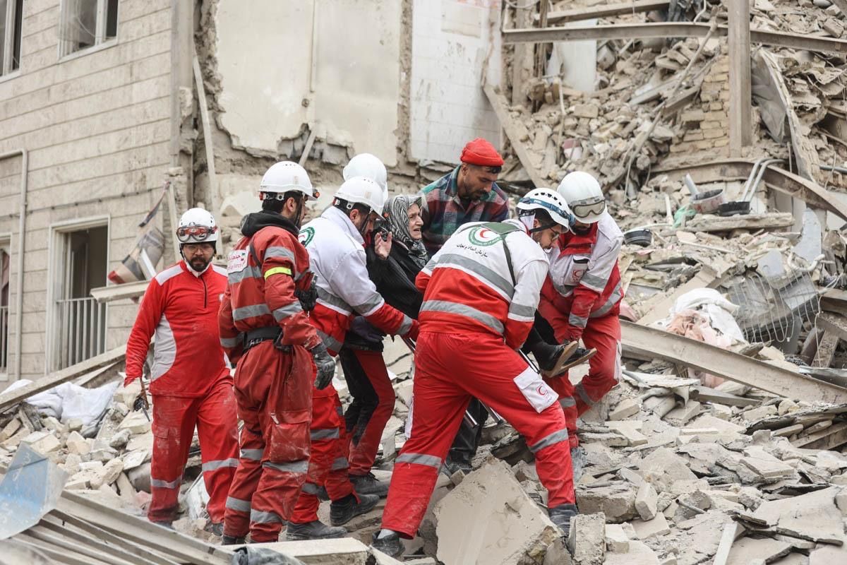 Rescue workers from the Iranian Red Crescent carry an elderly woman from the rubble of a damaged building in Tehran, amid US-Israeli conflict with Iran, March 16, 2026