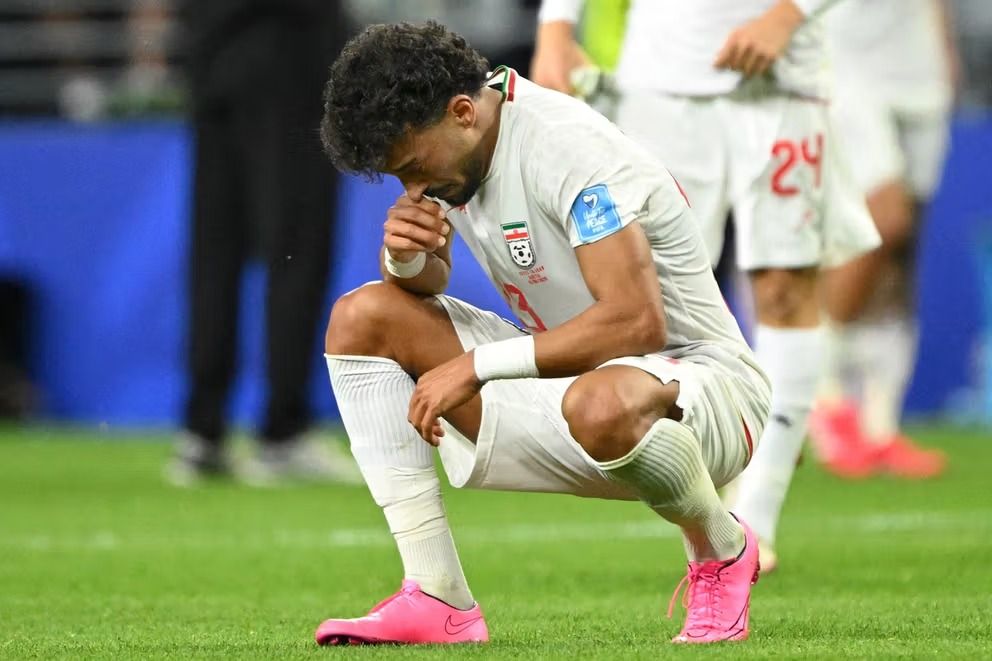 National football team player Ramin Rezaeian crouches on the pitch after the team's elimination from the FIFA World Cup 2026.