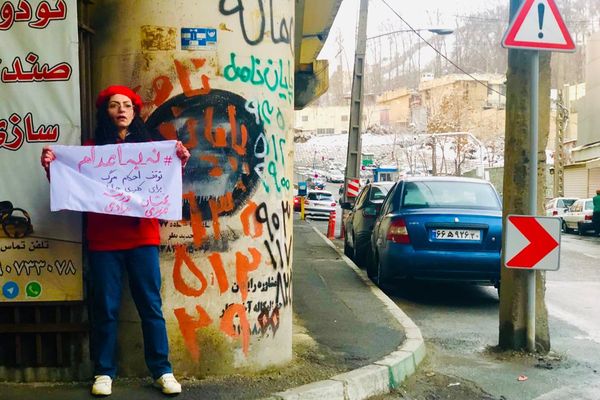 سجينة سياسية إيرانية ترفع لافتة "لا للإعدام" أمام سجن إيفين.. بعد إطلاق سراحها