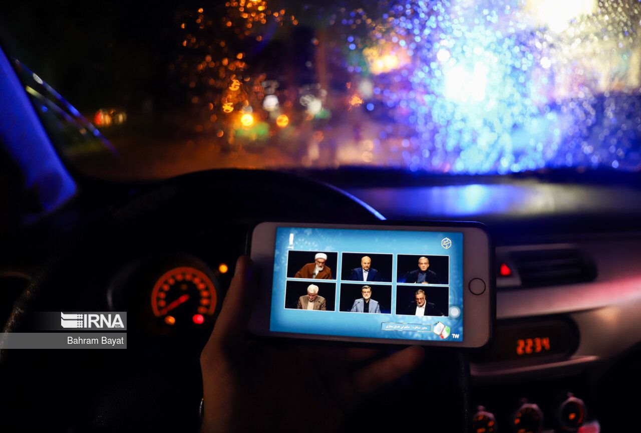 An Iranian watching a televised debate for Iran's snap elections (June 2024) 