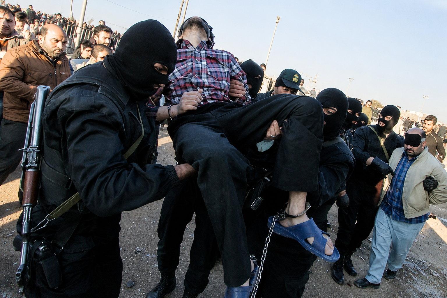 File photo: Masked men take part in a public execution in Iran
