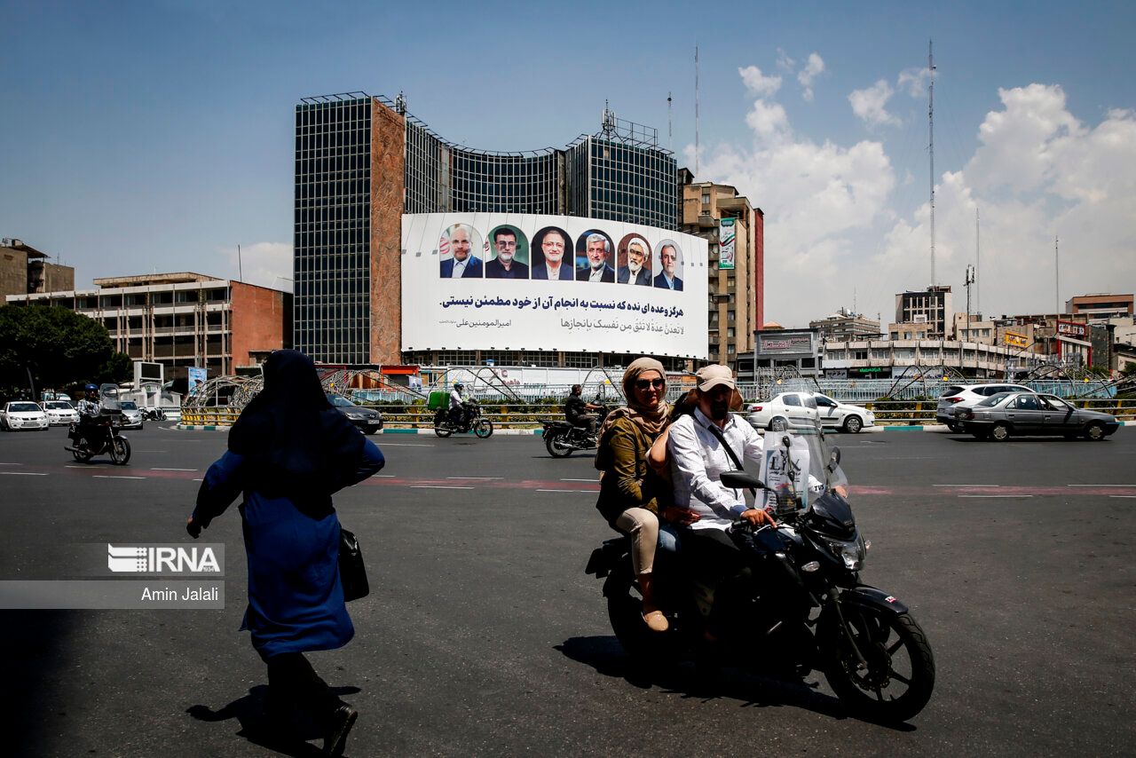 A giant electoral banner featuring portraits of Iran's early presidential elections candidates that is hanging on a governmental building in downtown Tehran (June 2024)