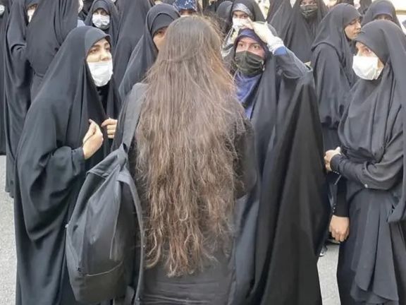 Students gathere at Al-Zahra all-female university in Tehran, with one student having removed her headscarf on Wednesday