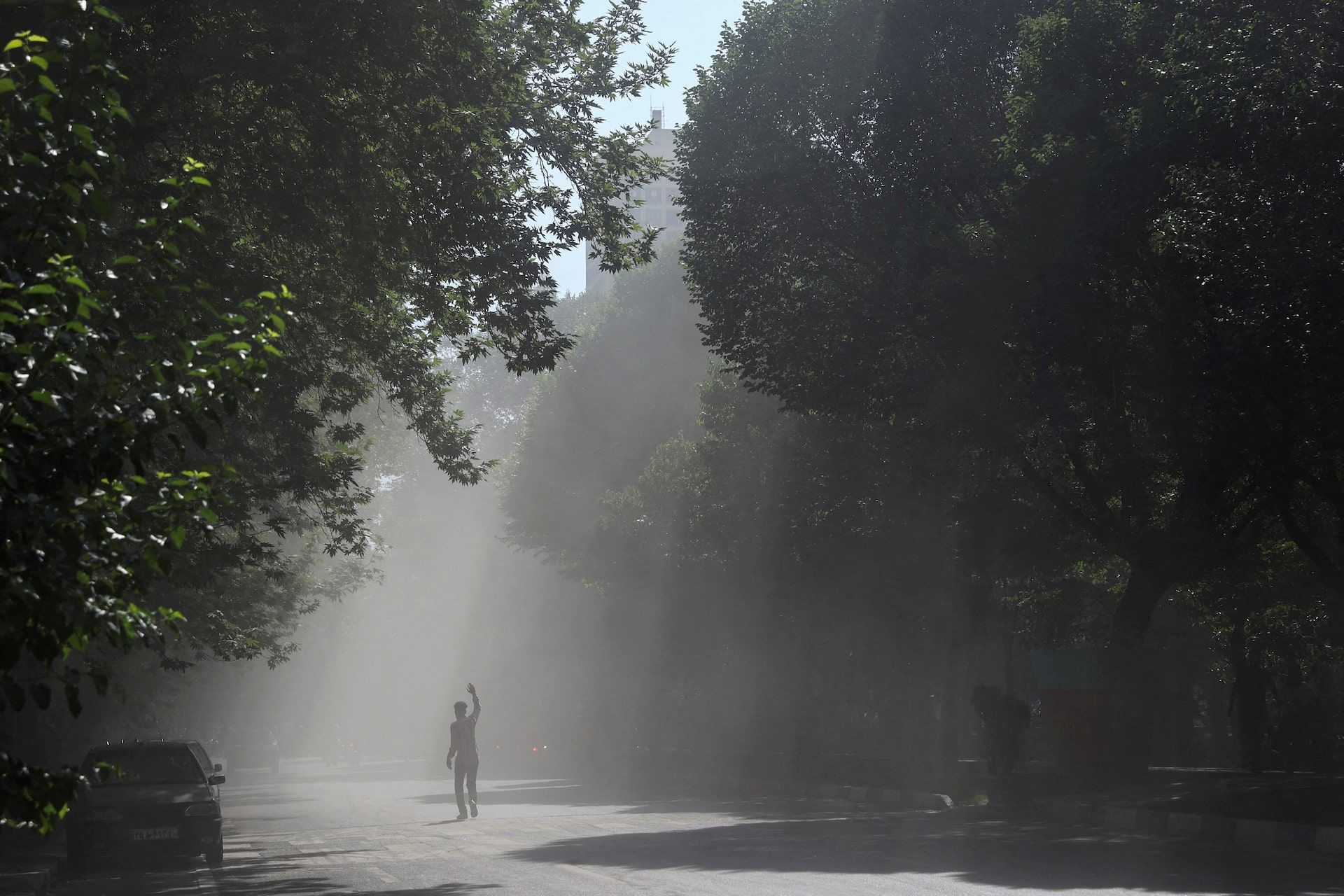A man walks through the smoke of an explosion following the Israeli strikes on Iran, in the centre of Tehran, Iran, June 15, 2025. 