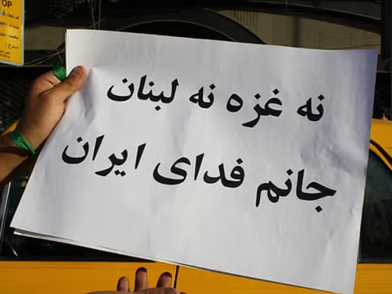 A placard held by an Iranian protester reads: “Neither Gaza nor Lebanon, my life for Iran.”
