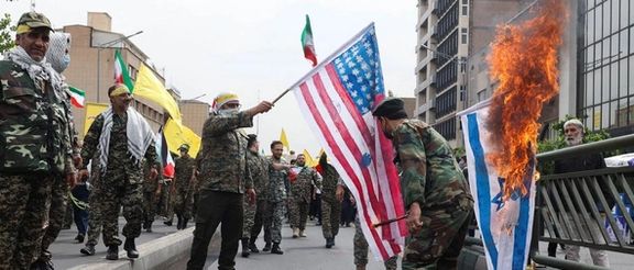 Men in military uniforms setting fire to Israeli and US flags during Quds day rallies in Tehran on April 29, 2022