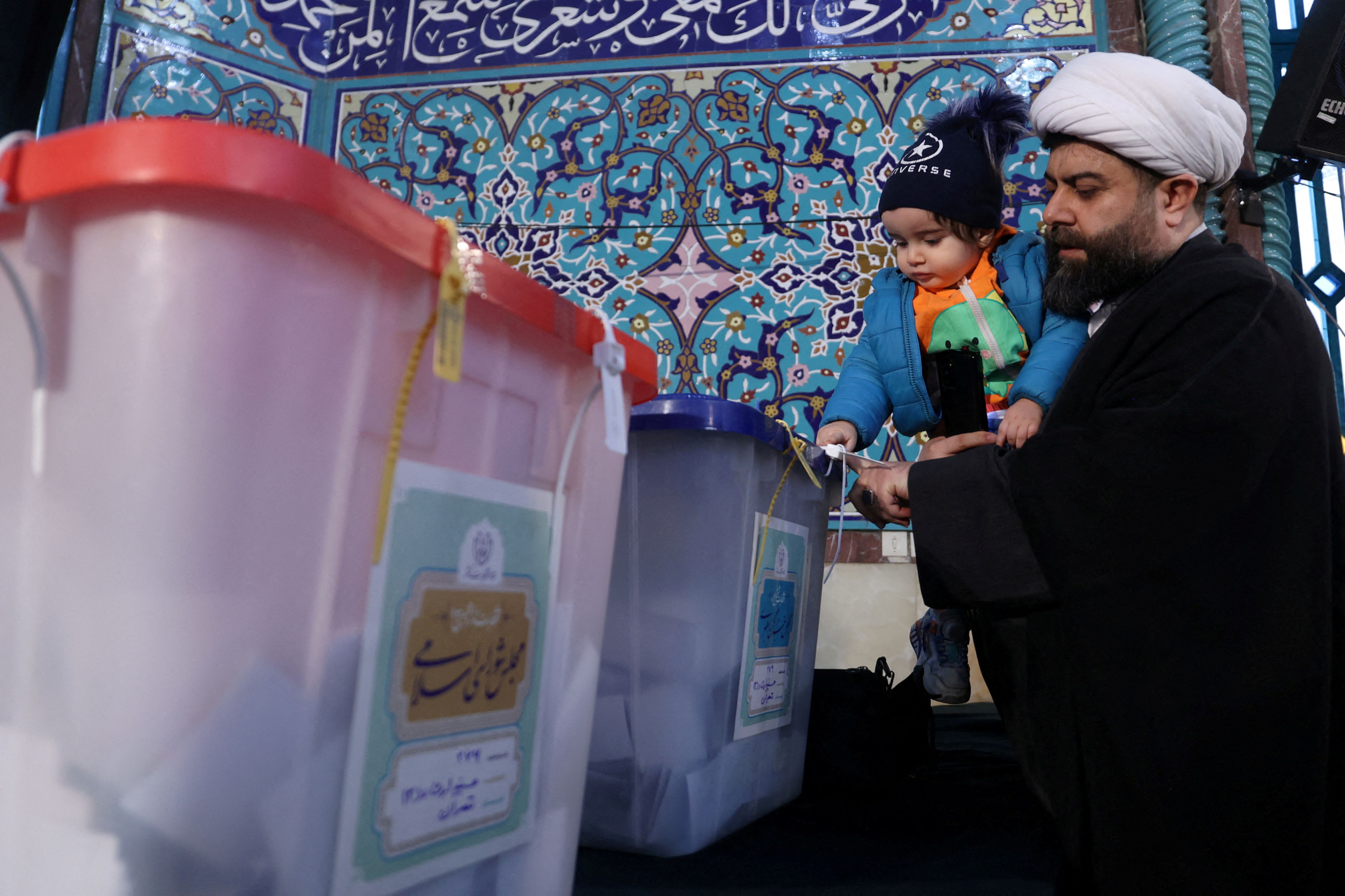  An Iranian cleric casts his vote during parliamentary elections at a polling station in Tehran, Iran, March 1, 2024.