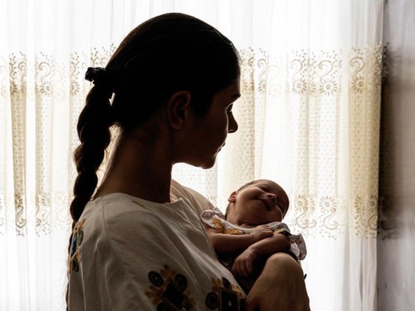 Photos published and later removed by Iranian state media showed an influencer with a baby placed through Iran’s Mizban temporary foster care program.