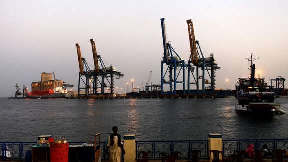 A man stands opposite the modern port at the harbour in Port Sudan at Red Sea State February 24, 2014.
