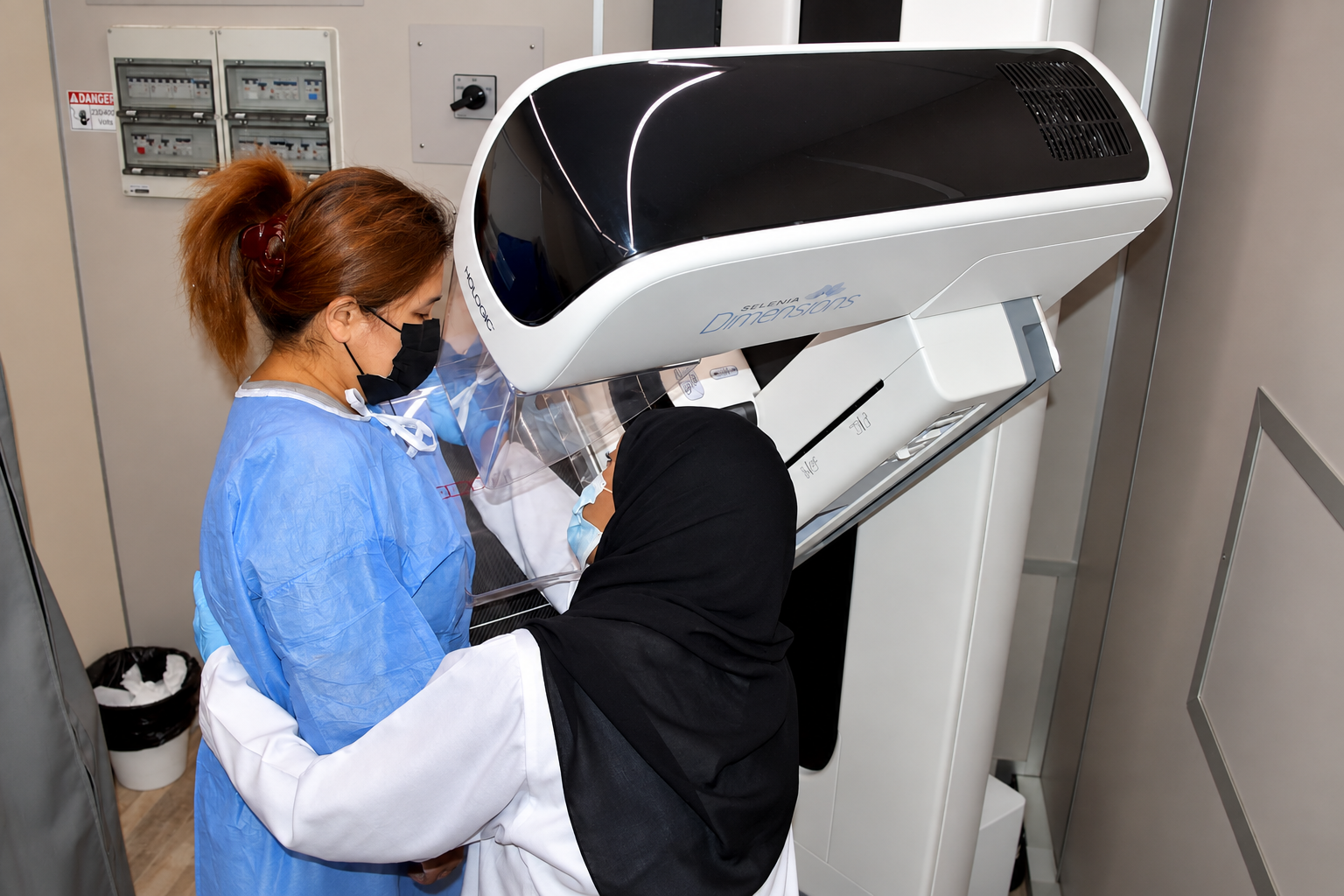 A woman undergoes a mammogram at a medical imaging center.