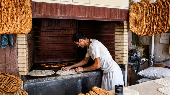 A baker prepares traditional flatbread Barbari at a bakery in Iran.