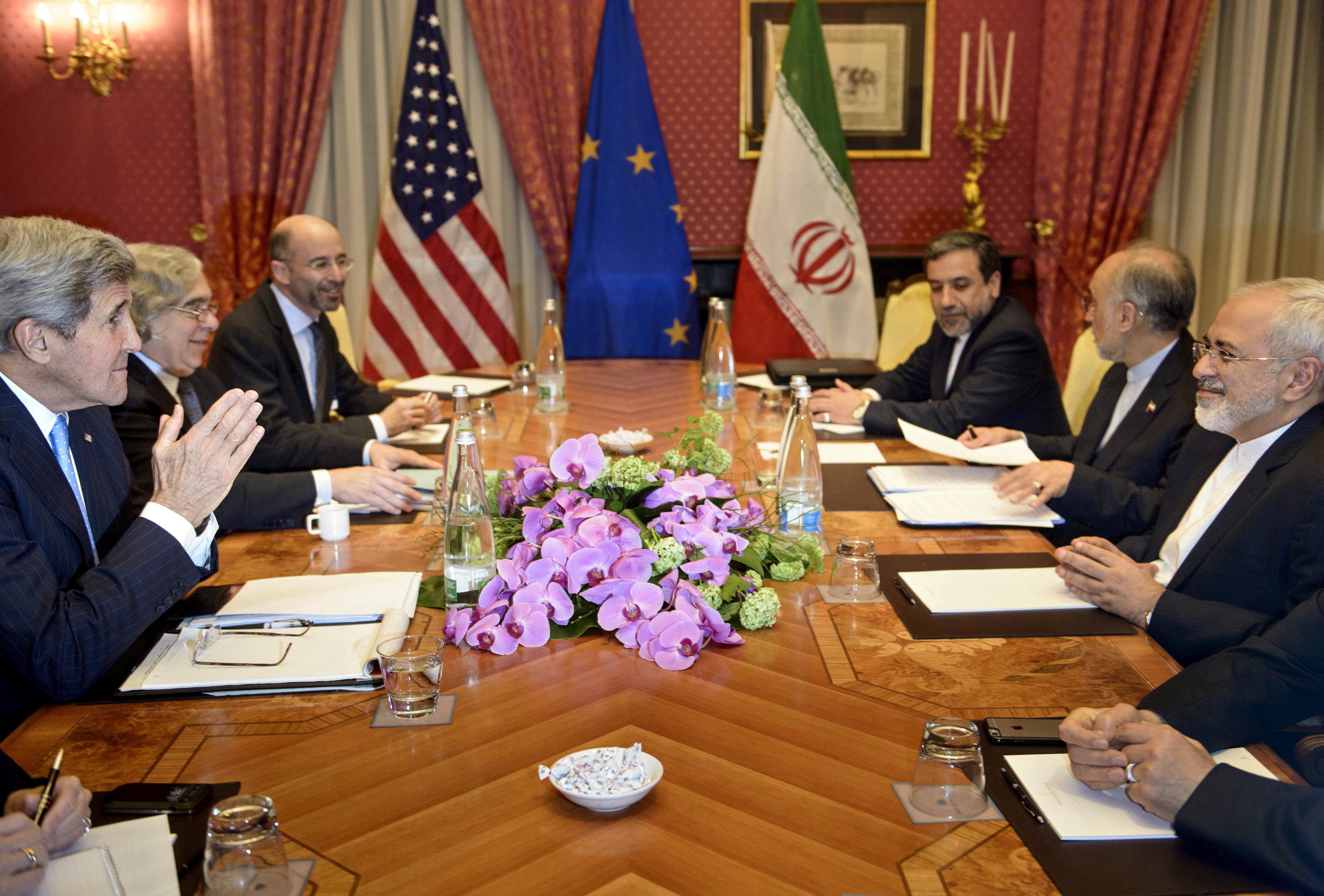 FILE PHOTO: US Secretary of State John Kerry (bottom left), US National Security Council member Rob Malley (top left), Iranian Deputy Foreign Minister Abbas Araghchi (top right), Head of Iran Atomic Energy Organization Ali Akbar Salehi, and Iranian Foreign Minister Javad Zarif (bottom right) wait to start a meeting at the Beau Rivage Palace Hotel in Lausanne March 29, 2015.