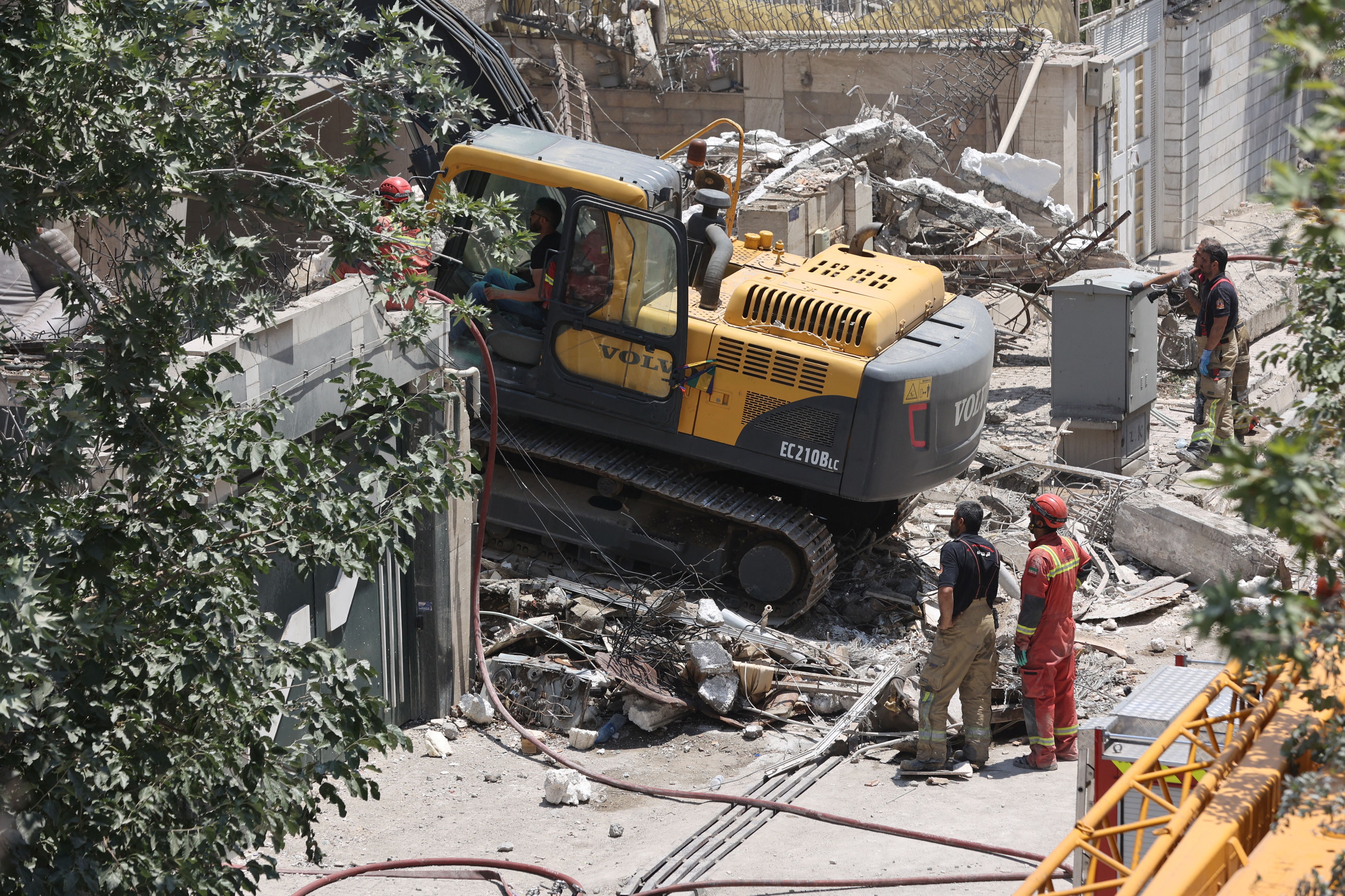 Rescuers work at the site of a damaged building, in the aftermath of Israeli strikes, in Tehran, Iran, June 14, 2025.