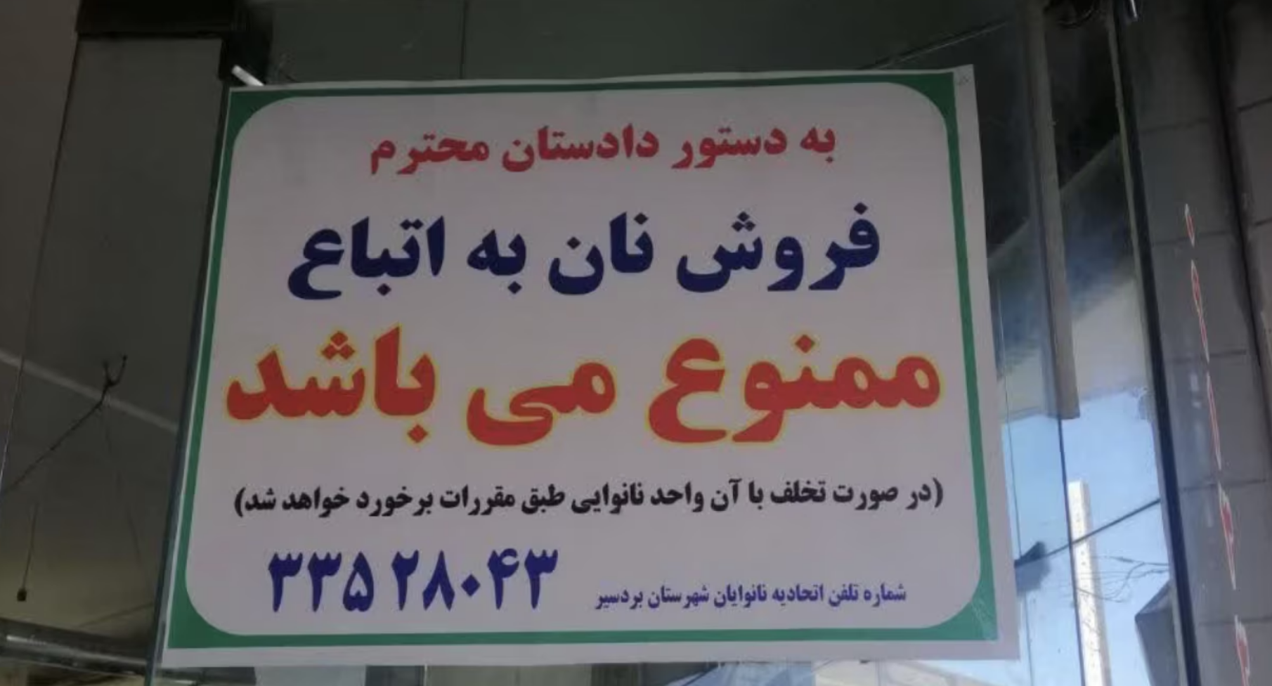 A photo posted on a bakery's entrance states, "By order of the prosecutor, the sale of bread to foreign nationals is prohibited," warning that violations will result in action against the business. 