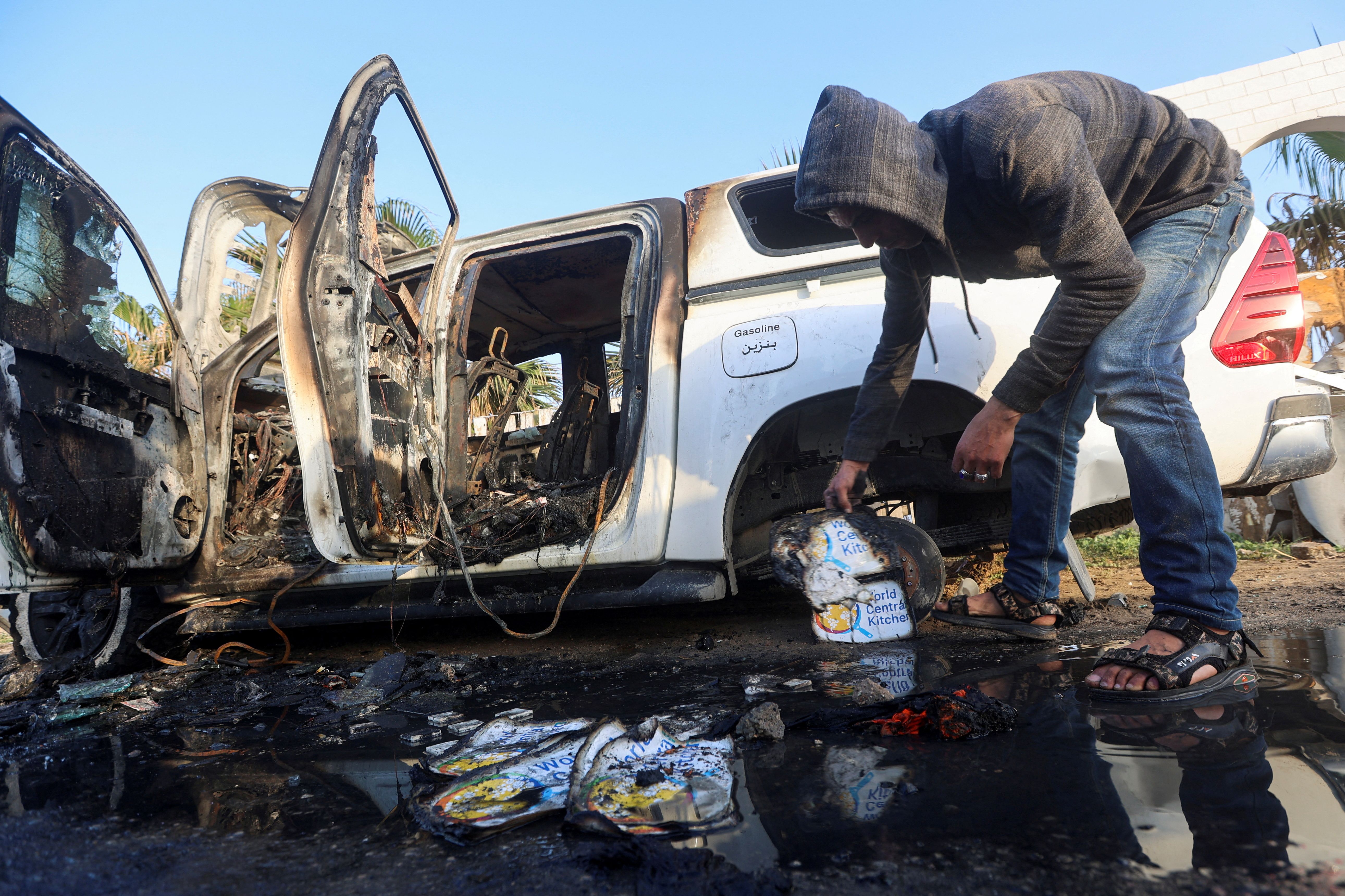 A Palestinian inspects near a vehicle where employees from the World Central Kitchen (WCK), including foreigners, were killed in an Israeli airstrike, in Deir Al-Balah, in the central Gaza, Strip April 2, 2024. 