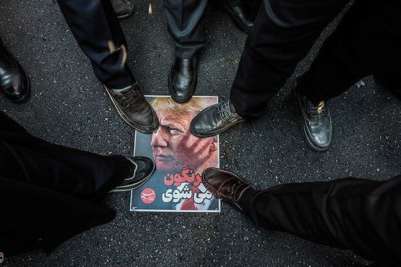 A printed image of US president Donald Trump is walked over during a state-sponsored rally in Tehran, Iran, January 12, 2026