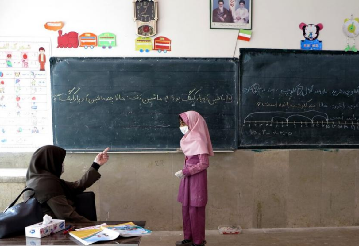 A student standing in front of a teacher in a classroom in Iran. (File photo)
