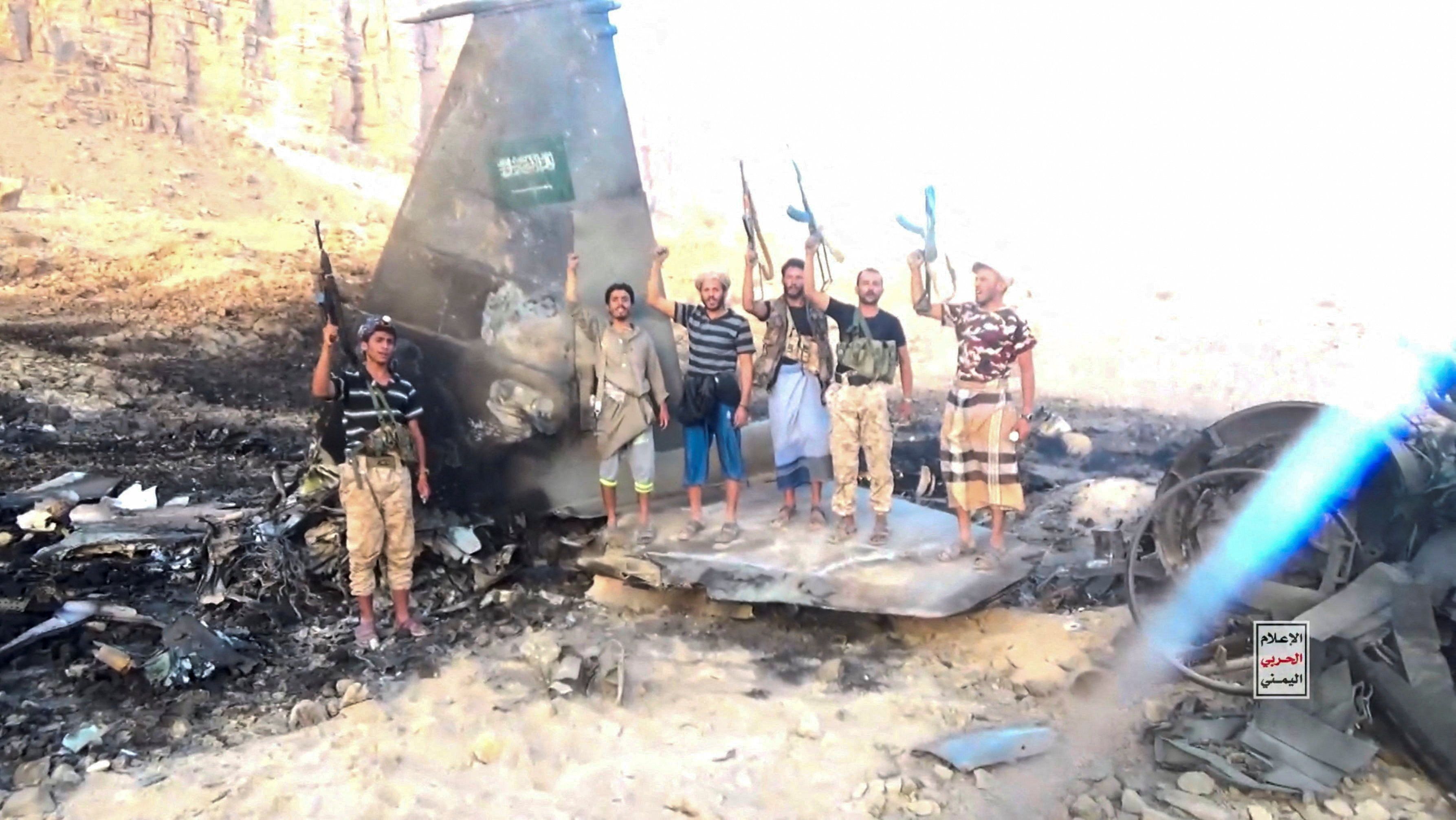 Houthi fighters stand in front of what they say is a downed Saudi jet, at a location given as Yemen, in this still image from a handout video released on September 16, 2026. 