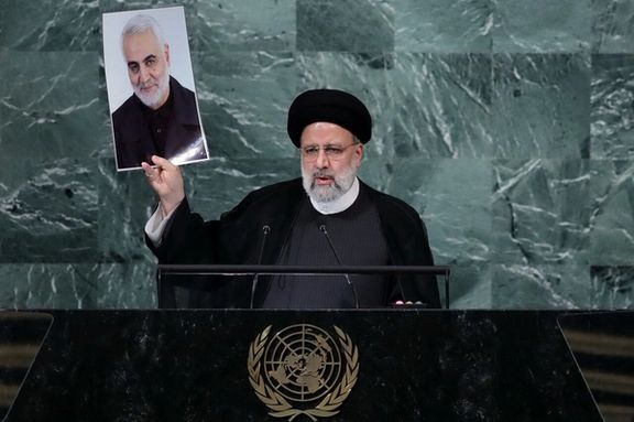 Iran's President Ebrahim Raisi raising the picture of IRGC's Qasem Soleimani during his speech at the UN General Assembly.