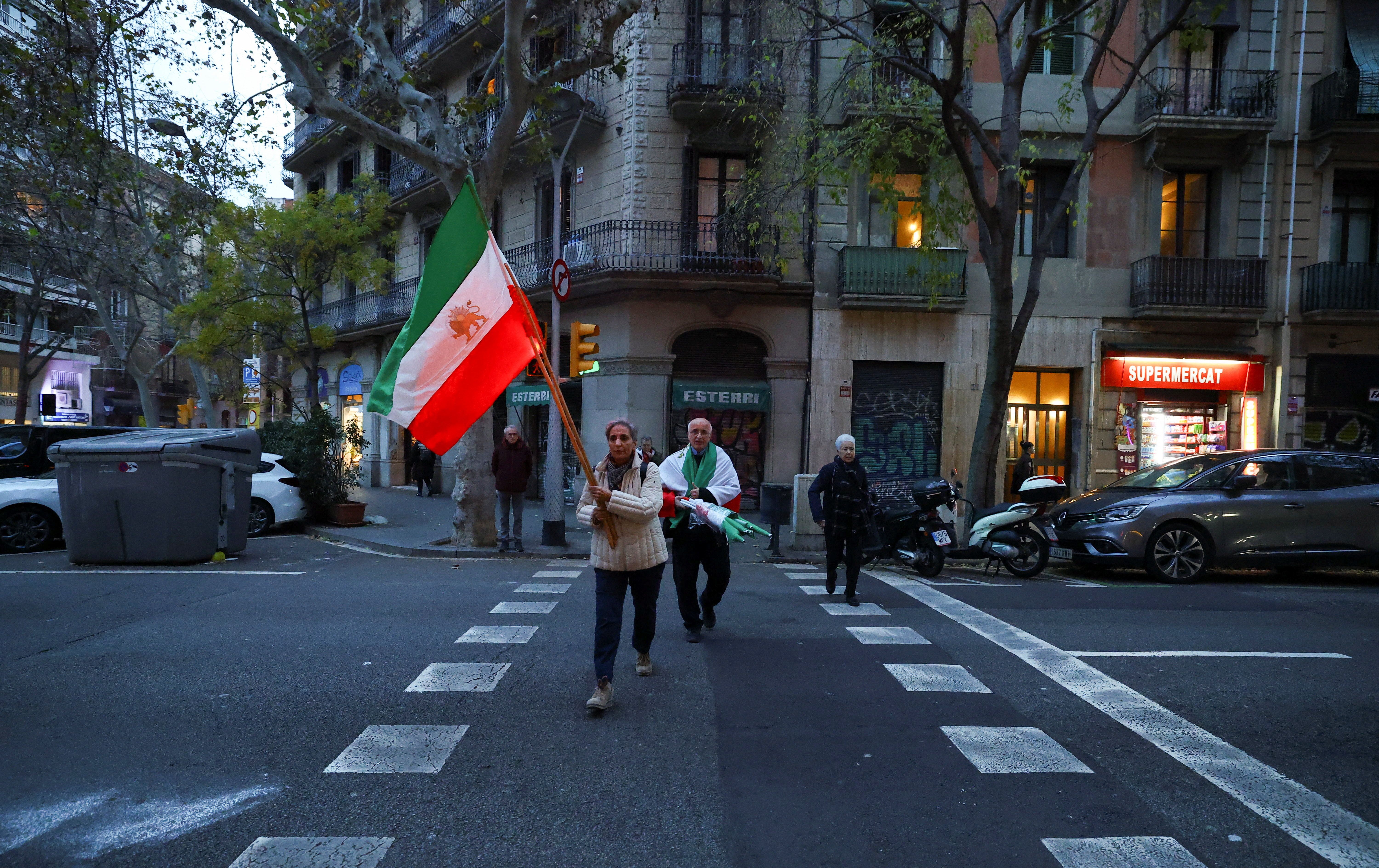 Said and Guiti, who have lived in Spain for over 40 years as refugees from Iran, carry flags to attend a demonstration in support of the national protests in Iran, in Barcelona, Spain January 13, 2026. 