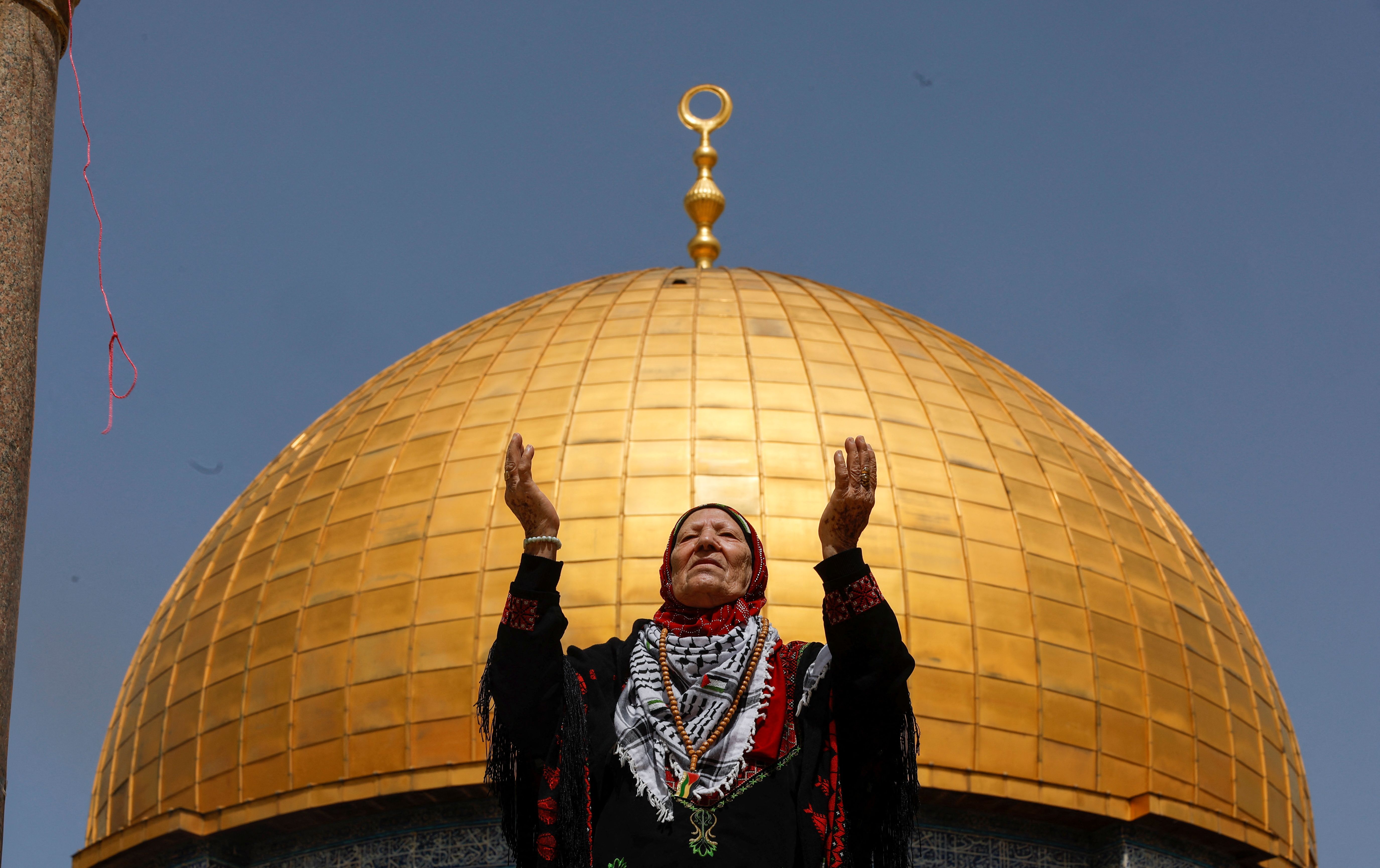 A woman prays as Palestinian Muslims attend Friday prayers of the Muslim holy month of Ramadan, on the compound known to Muslims as the Noble Sanctuary and to Jews as the Temple Mount, in Jerusalem's Old City, April 7, 2023. 