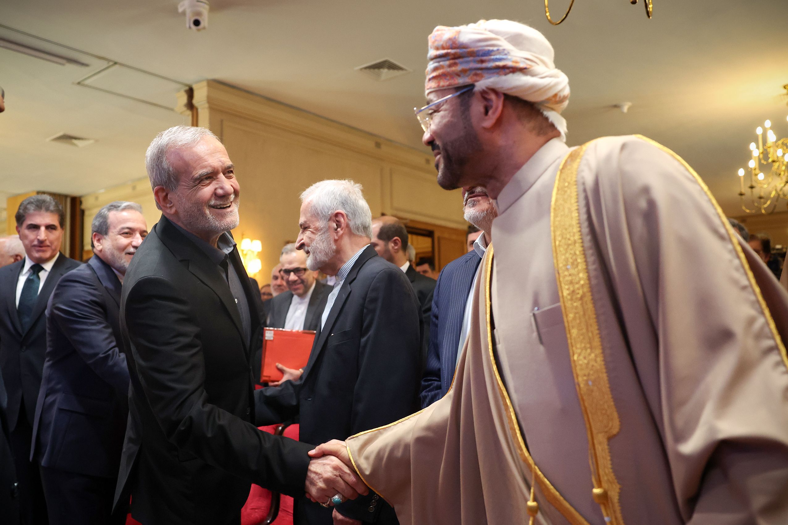 Iranian President Masoud Pezeshkian (left) shaking hands with Omani Foreign Minister Badr bin Hamad al-Busaidi during the Tehran Dialogue Forum on May 18 