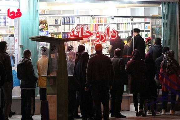 Iranians stand in line outside a drugstore
