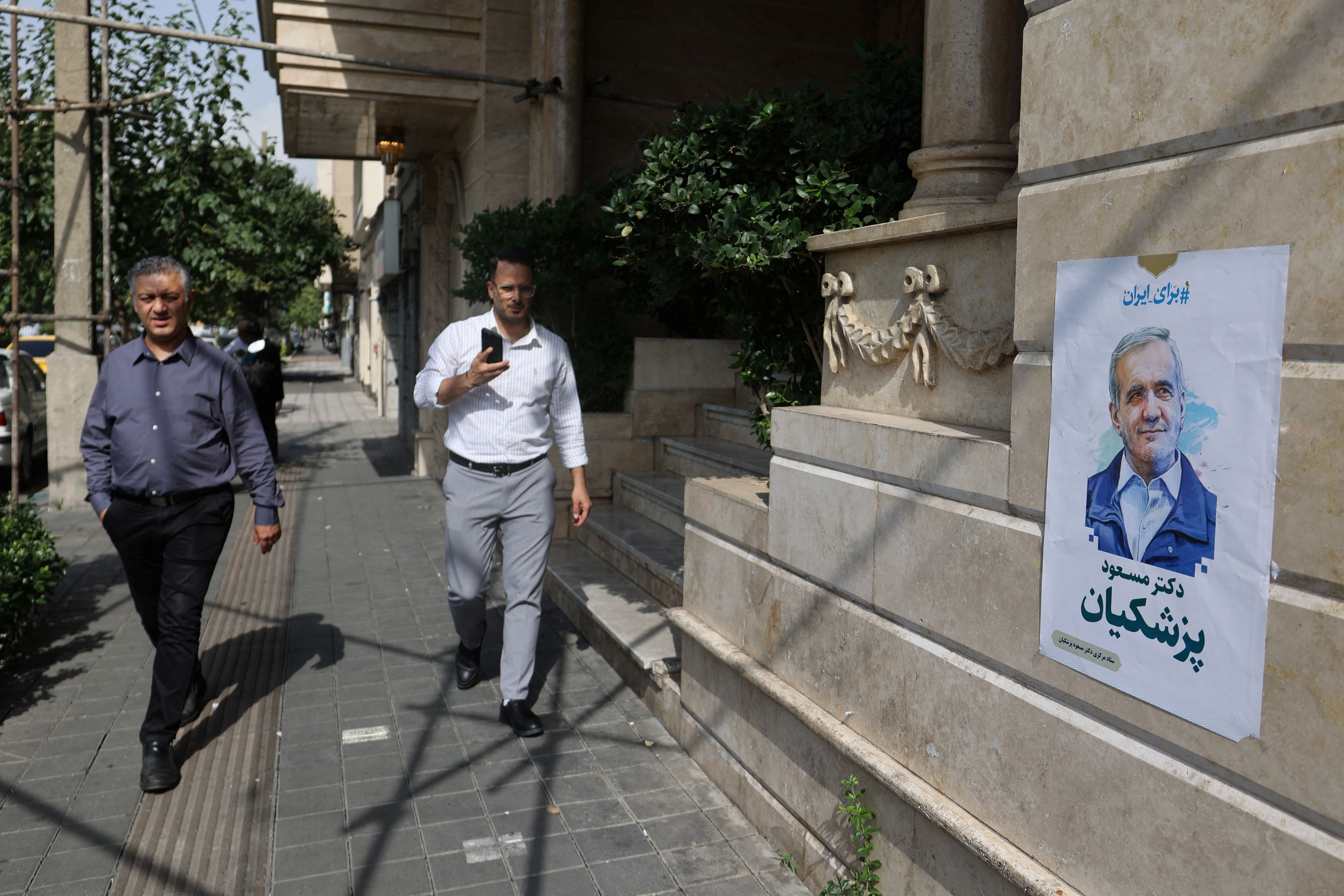 A poster of presidential candidate Masoud Pezeshkian is displayed on a street in Tehran, Iran, June 29, 2024.