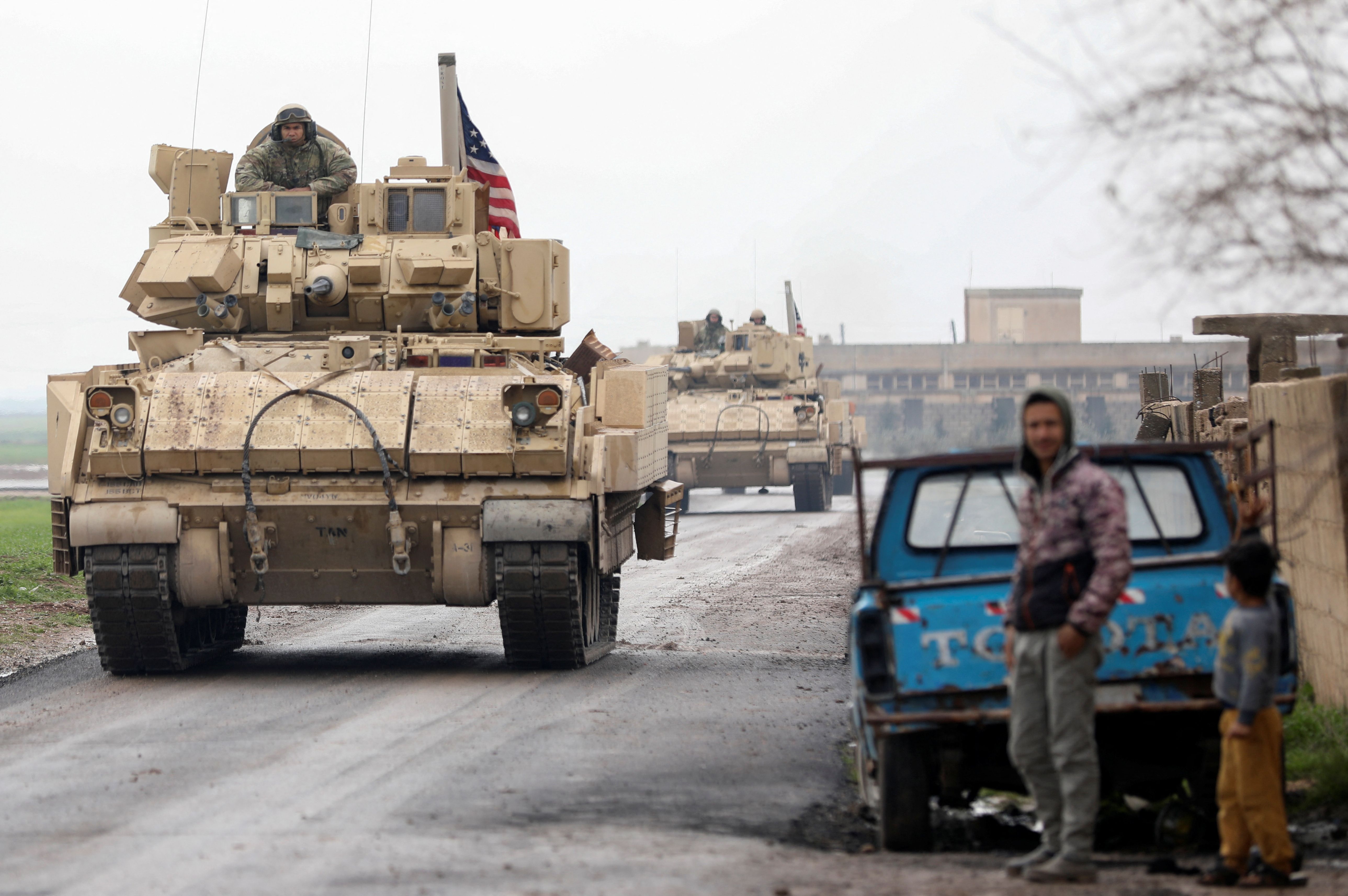 Residents stand on a street during a joint US- Kurdish-led Syrian Democratic Forces (SDF) patrol in the countryside of Qamishli, in northeastern Syria February 8, 2024. 