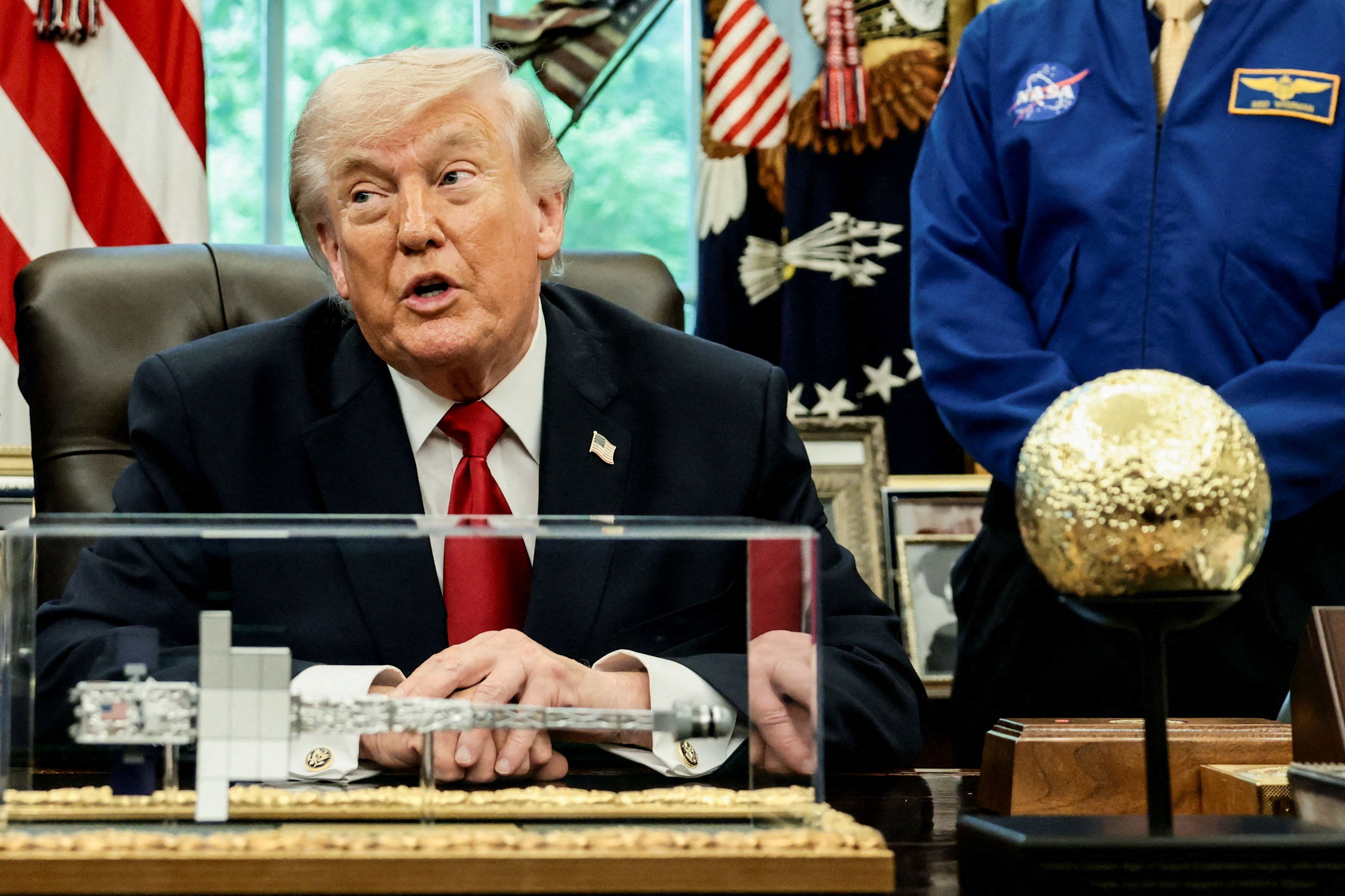 Artemis II astronauts, NASA Commander Reid Wiseman, NASA Pilot Victor Glover, NASA Mission Specialist Christina Koch and Canadian Space Agency (CSA) Mission Specialist Jeremy Hansen, and NASA Administrator Jared Isaacman flank US President Donald Trump as he takes questions from the media during an event in the Oval Office at the White House in Washington, DC, on April 29, 2026. 