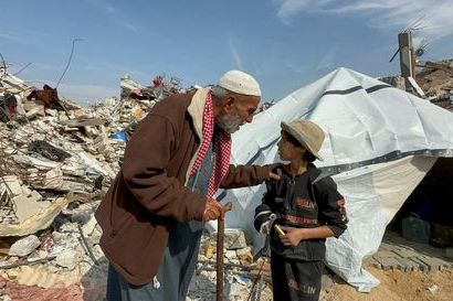 A Palestinian man, who was displaced at Israel's order during the war, speaks with a child after returning to his destroyed house, January 28, 2025