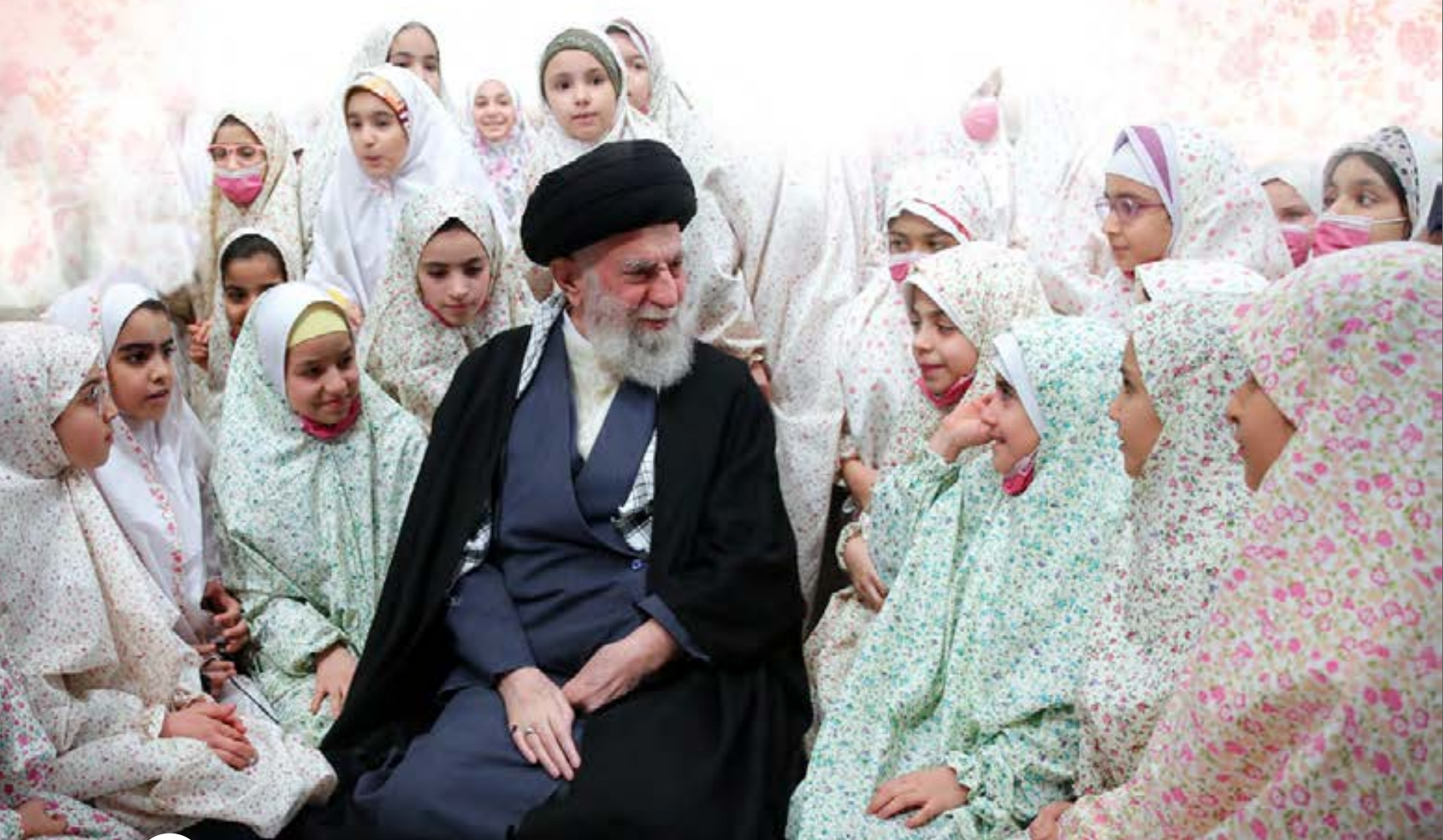 Supreme Leader Ali Khamenei meets with a group of Iranian schoolgirls in Tehran, an image featured in the new textbook “Defending Our Iran.” (undated)