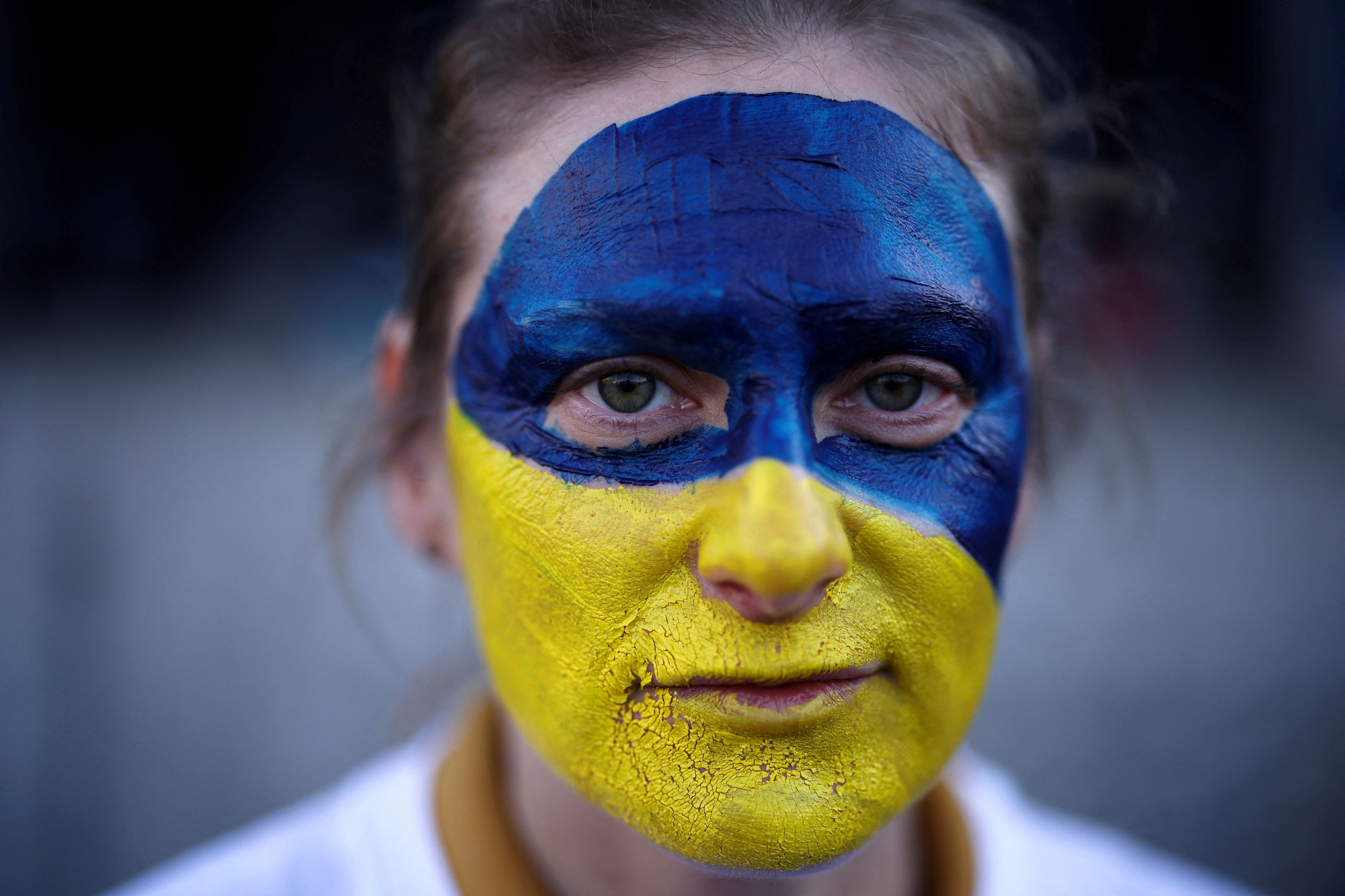 A woman with colors of the Ukrainian flag painted on her face in London. February 27, 2022
