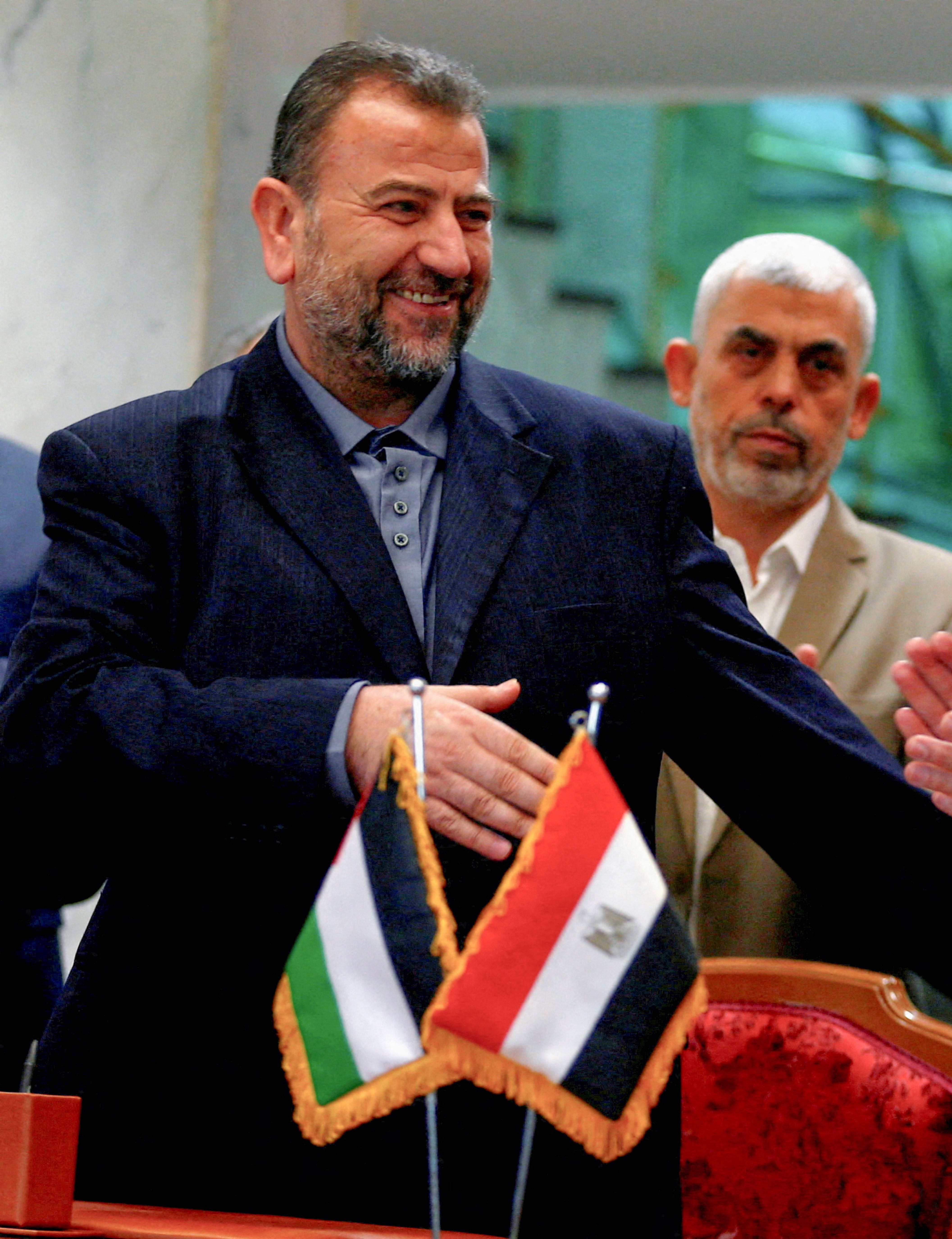 Head of Hamas delegation Saleh al-Arouri, with Gaza's Hamas leader Yahya Sinwar behind him, signs a reconciliation deal with Fatah leader Azzam Ahmad (not pictured), in Cairo, Egypt, October 12, 2017. 