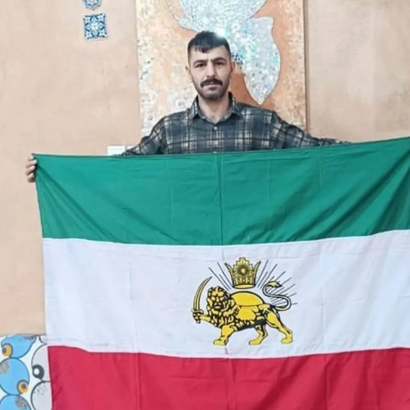 Abol (Hamid) Korkor with Iran's ancient flag with the Lion and Sun emblem