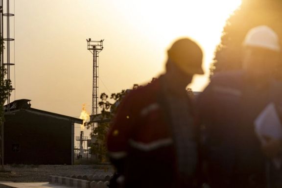 Oil workers walking at an oil/gas facility in the southern city of Kazerun