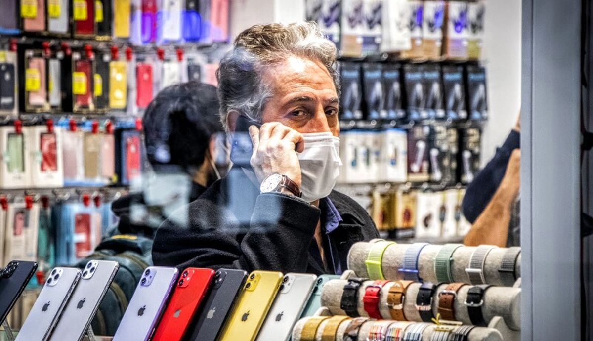 An Iranian man talking on his phone inside a cellphone store in Tehran (file photo)
