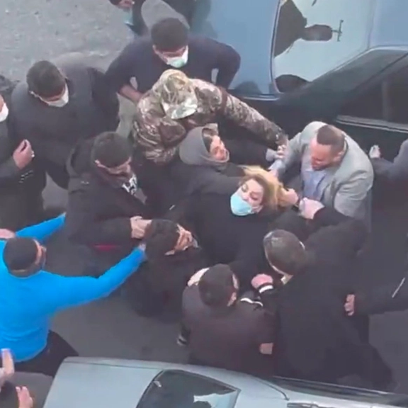 Plainclothes agents assaulting a mother outside an Iranian school where girls were poisoned by a mysterious gas. March 1, 2023