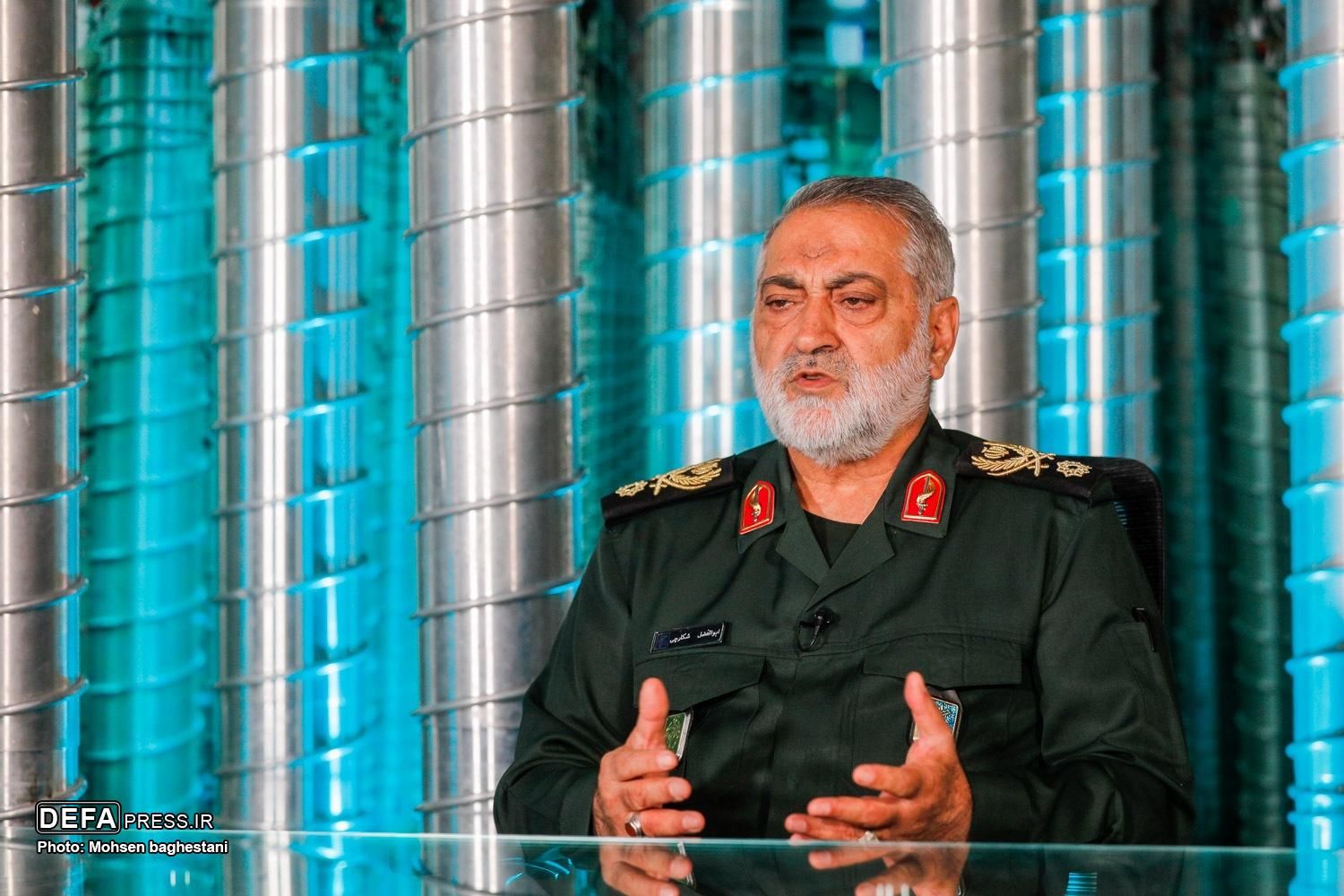 Abolfazl Shekarchi, spokesman for Iran’s armed forces, speaks on a program about the 12-day war, with centrifuge replicas forming the backdrop, September 24, 2026.