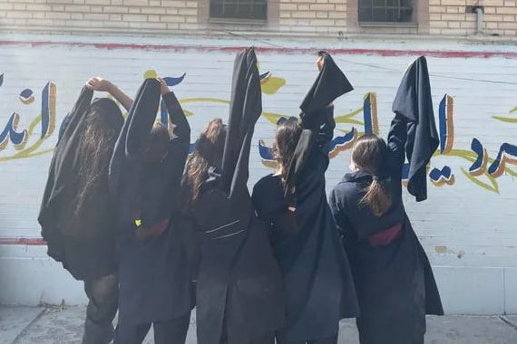 A group of schoolgirls removing their hijab in support of popular protests