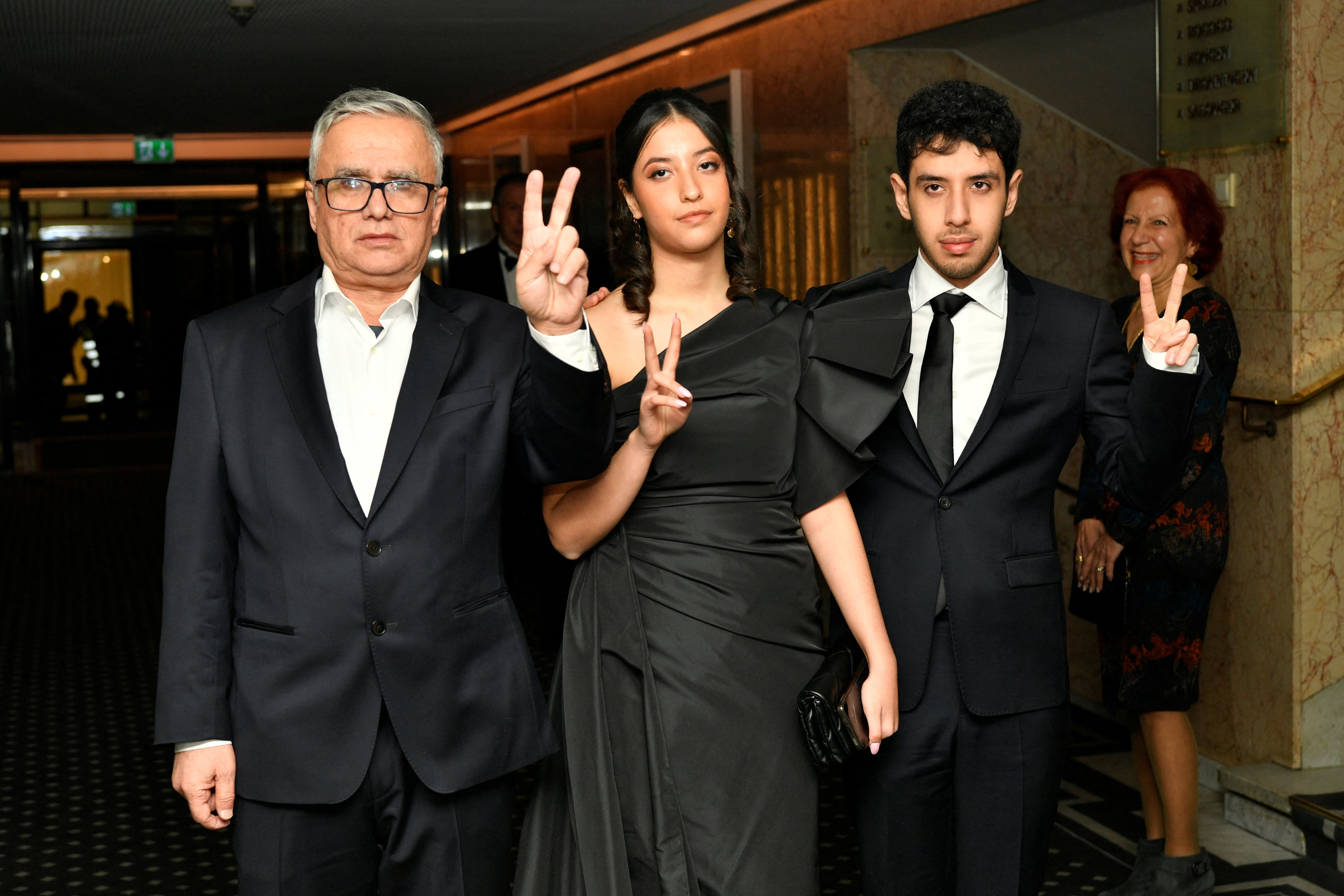 Kiana Rahmani (center) and Ali Rahmani (right), children of the 2023 Nobel Peace Prize laureate Narges Mohammadi, and her husband Taghi Rahmani, arrive at the Nobel banquet at the Grand Hotel in Oslo on December 10, 2023. 