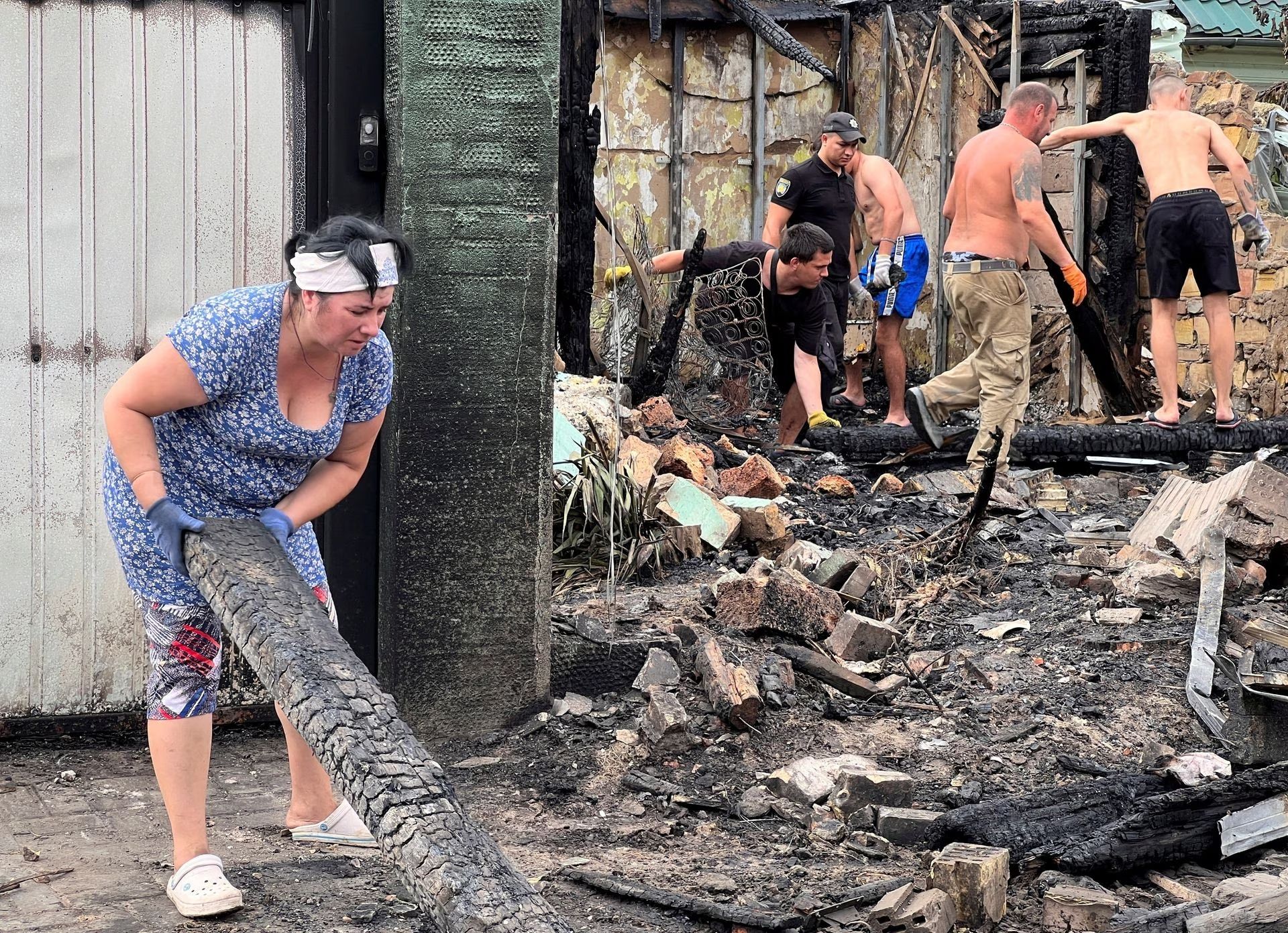 Local residents remove debris from buildings damaged by a Russian missile strike in the village of Tarasivka in Kyiv region Ukraine August 30, 2023.