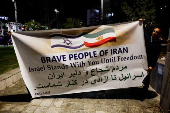 People hold a banner, as Israelis rally in support of the nationwide protests happening in Iran, in Holon, Israel, January 14, 2026.