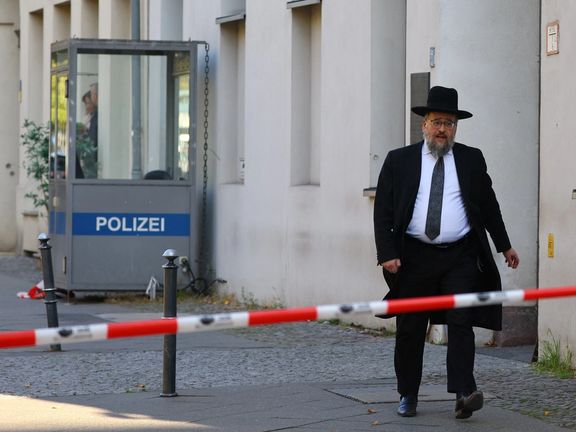 A member of the Jewish community walks behind barrier tape following a police lockdown of the area after two Molotov cocktails were thrown at the Skoblo Synagogue and Education Center overnight in Berlin, Germany, October 18, 2023.