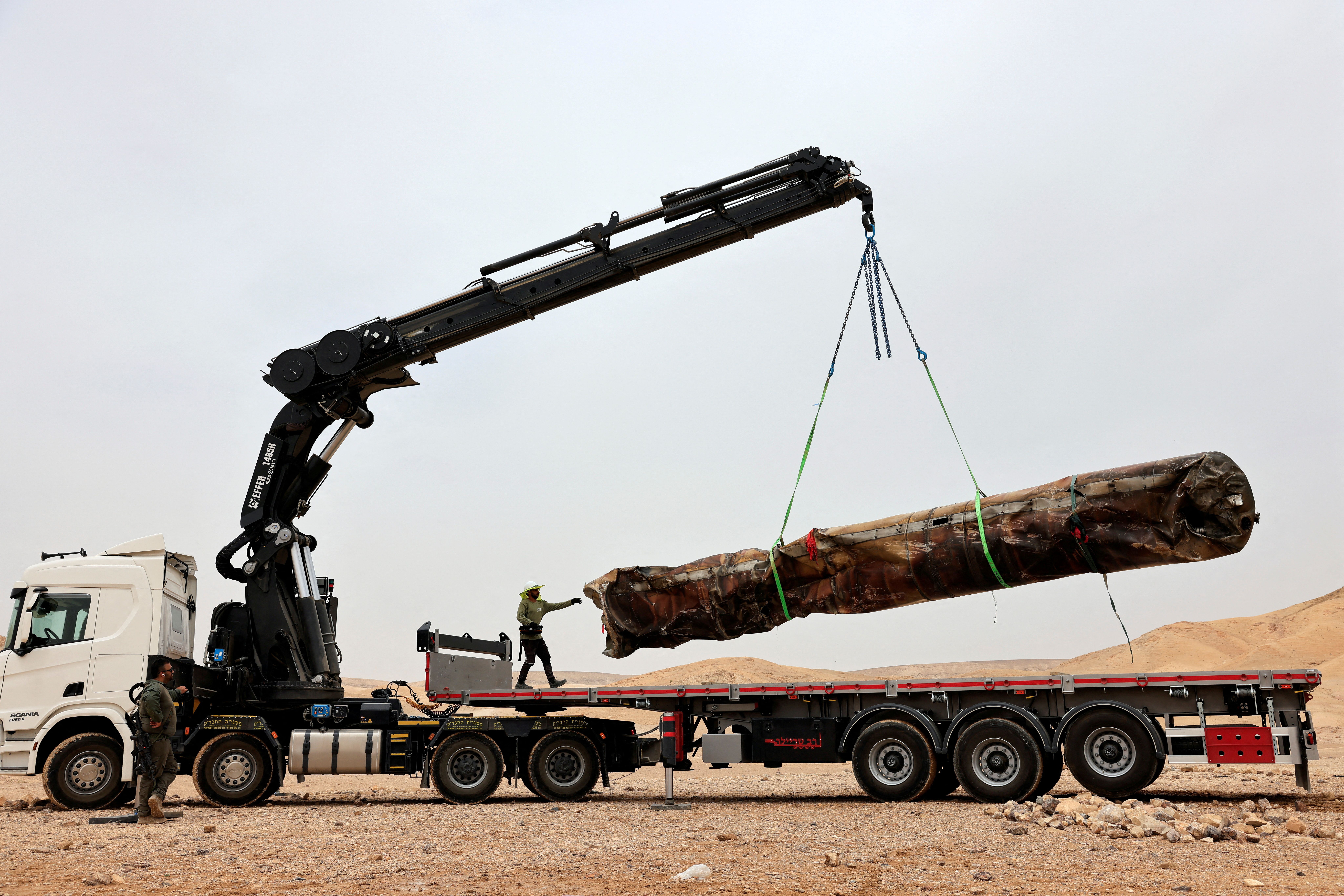 Military personnel load, onto a truck, apparent remains of a ballistic missile after it was evacuated from the location it was found lying in the desert, following a massive missile and drone attack by Iran on Israel, near the southern city of Arad, Israel April 26, 2024.