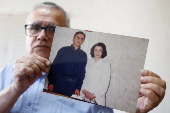 Taghi Ramahi, husband of Narges Mohammadi, a jailed Iranian women's rights advocate, who won the 2023 Nobel Peace Prize, poses with an undated photo of himself and his wife, during an interview at his home in Paris, France, October 6, 2023.