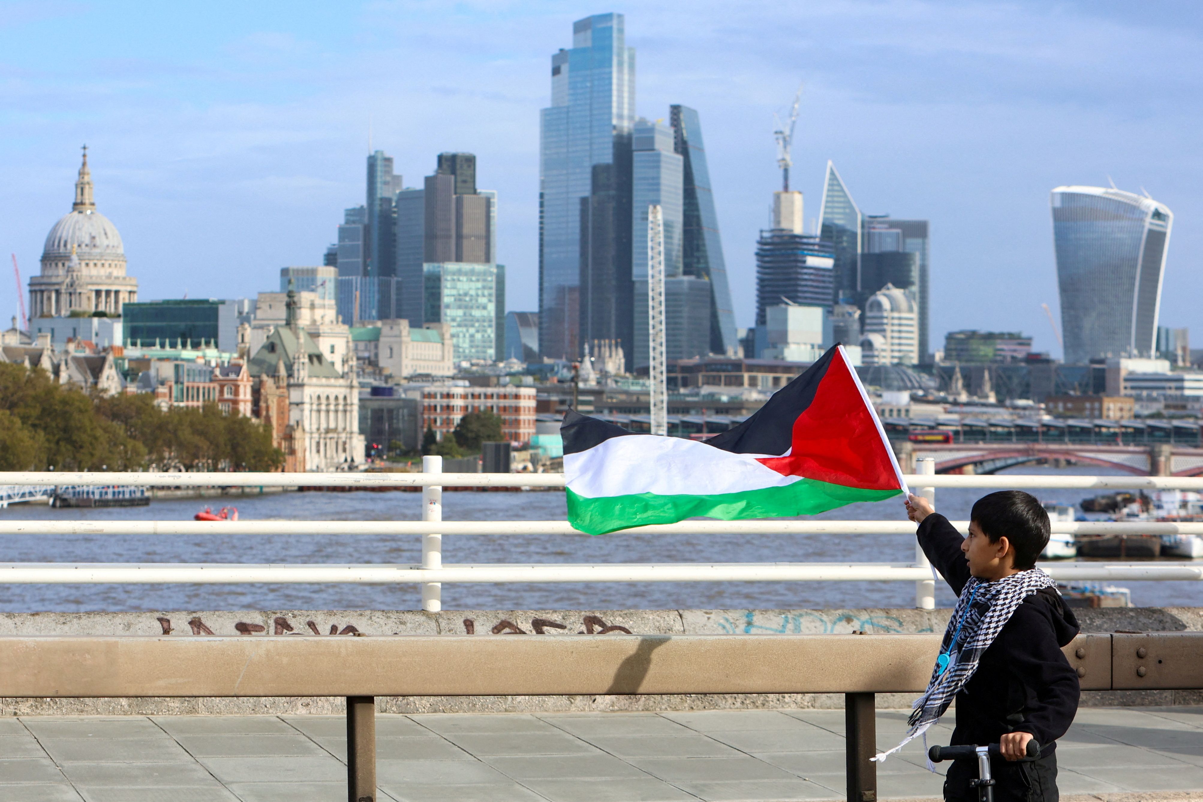 A boy holds a Palestinian flag as demonstrators protest in solidarity with Palestinians in Gaza, amid the ongoing conflict between Israel and the Palestinian Islamist group Hamas, in London, Britain, October 28, 2023
