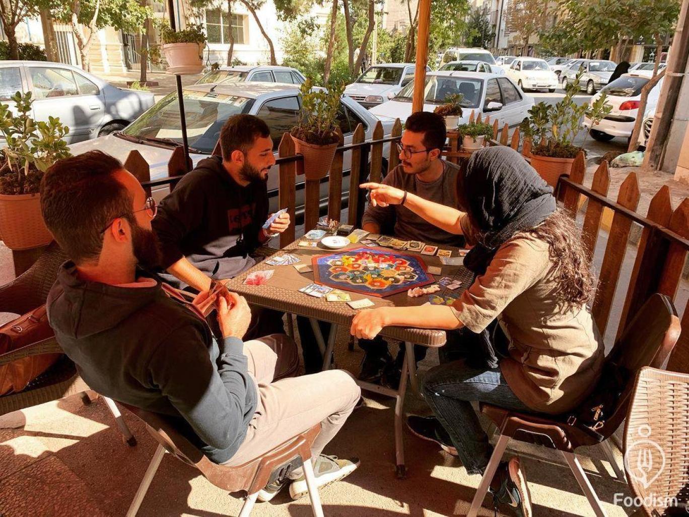 Iranian youths playing a boardgame at a café   