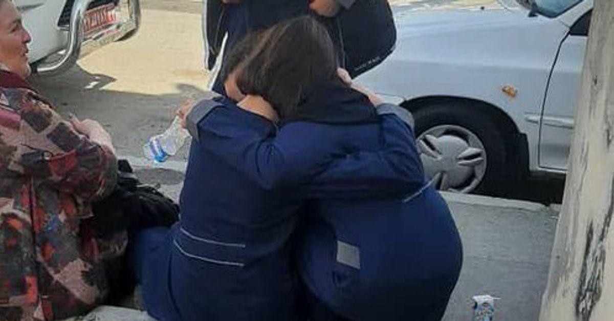 Two schoolgirls hugging each other after a poisonous gas attack at their school (March 2023)